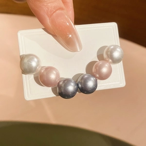 Macro shot of s925 silver large pearl earring set in white pink and gray tones