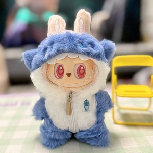 Close-up of blue monster outfit with zipper for Labubu plush doll on a yellow chair