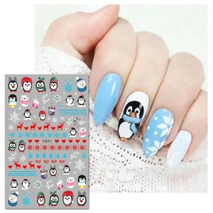 Christmas nail stickers with penguin and snowflake designs in blue and red on white lace background