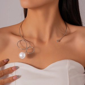 Close-up of minimalist silver metallic collar necklace with large white pearl on model