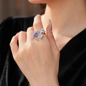 Close-up of a large zircon flower ring with a purple oval stone on a model hand