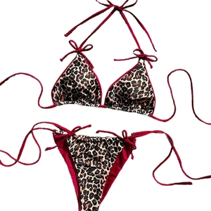 Leopard print two-piece bikini set with red trim and halter neck tie closure