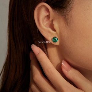 Elegant 925 sterling silver 8mm round Paraiba green stud earring on model's ear