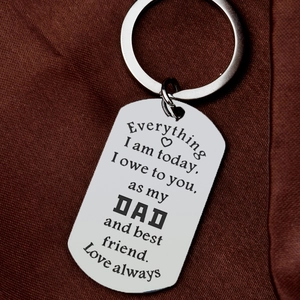 Polished stainless steel keychain with engraved message for parents on a brown fabric background