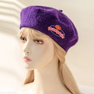Detailaufnahme der dunkelvioletten Wollbaske mit Kürbis-Stickerei und weicher Textur