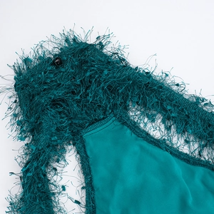Detail of the halter neckline featuring dark green textured fringe and satin fabric finish