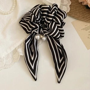 Detail of striped bow hair scrunchie with large pearls and sparkling rhinestone accents