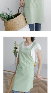 Detail of light green washed linen apron with wide straps and large front pocket