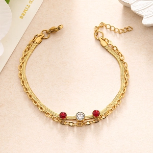 Detail of gold double-layer chain bracelet with sparkling red and white rhinestones