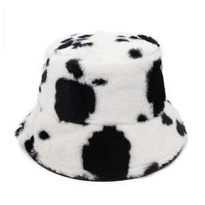 Winter plush bucket hat with retro black and white cow print and fluffy faux fur texture