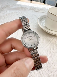 Detailed shot of silver ladies watch with rhinestone bezel and mother of pearl dial