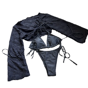 Three-piece black bikini set with high-cut bottoms and textured mesh long-sleeve cover-up