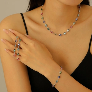 Close-up of colorful clover necklace and bracelet set in silver finish on a model