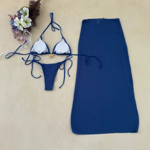 Flat lay of navy blue 3-piece bikini set with starfish buckle and mesh maxi skirt