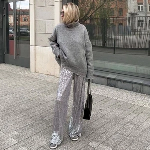 Detail showing shiny silver sequins on wide-leg trousers for holiday party wear