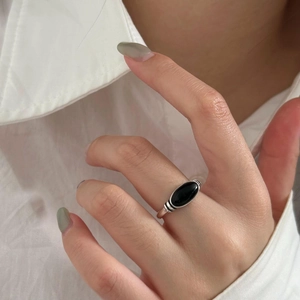 Close-up of a 925 sterling silver ring with oval black agate worn on a finger