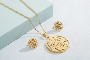 Detailed view of golden Hamsa Hand necklace and earrings set with intricate filigree