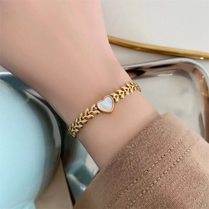 Elegant 18K gold-plated titanium steel bracelet featuring a heart-shaped white shell charm