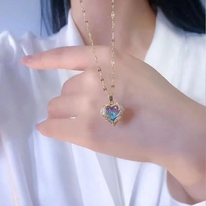 Detailed macro of a gold heart necklace with a blue purple gradient crystal pendant
