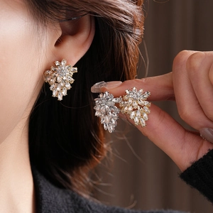 Detail of floral earrings with sparkling crystals in gold and silver plating