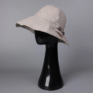 Dettaglio del cappello da sole a righe in cotone e lino con cordino antivento