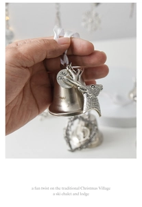 Detail of silver Christmas bell pendant featuring reindeer head and Merry Christmas tag