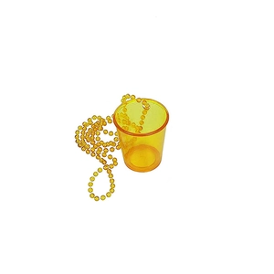Close-up of orange transparent plastic party shot glass with yellow bead chain necklace