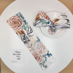 Floral twist hair bun maker set with pink rose patterns on a minimalist white table