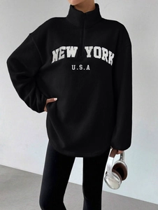 Détail du tissu polaire et broderie New York sur le sweat-shirt noir oversize