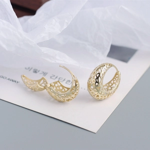 Close-up of gold hollow geometric pattern hoop earrings with secure snap closure