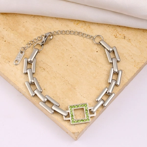 Macro shot of silver stainless steel bracelet featuring a green zircon square pendant
