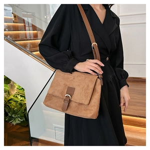 Detail of vintage brown frosted suede satchel featuring leather strap and retro metal buckle