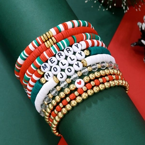 Gros plan de bracelets de Noël avec perles Merry Holly Joy sur un cylindre vert