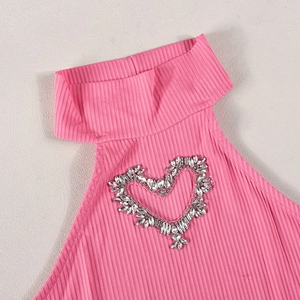 Nahaufnahme von rosa geripptem Strickstoff mit funkelndem Strass-Herz-Dekor