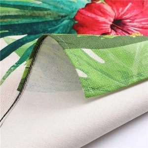 Close-up of tropical palm leaf and hibiscus flower print on textured linen fabric