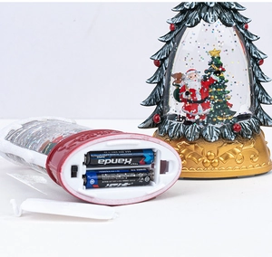 Detail of Christmas tree snow globe with AAA battery compartment and interior Santa
