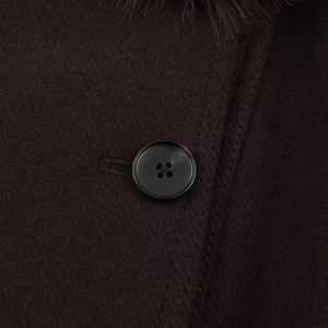 Détail d'un manteau en laine marron avec un bouton noir à quatre trous et col en fourrure