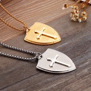 Detail of gold and silver shield pendants with cross relief and engraved scripture text