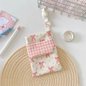 Detailed macro view of a floral nurse pocket organizer with pink bow and canvas texture
