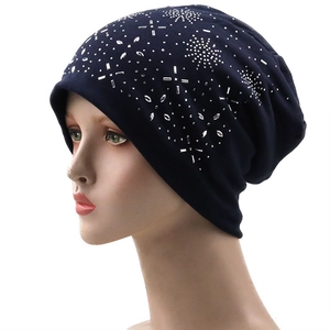 Detail of navy knit beanie featuring silver rhinestone star patterns on a model head