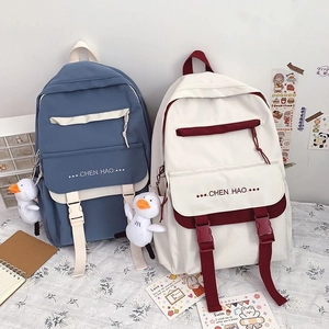 Detailed view of dual-color school backpacks with cute duck pendant and side buckles