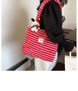 Close-up of fluffy striped tote bag with cute dog pendant and embroidered text label