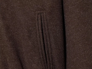 Close-up of the fine stitching on the deep brown wool-blend pocket of this hooded jacket