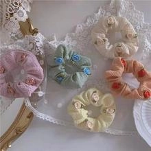 Detailed set of five pastel woven rose scrunchies featuring floral fabric textures