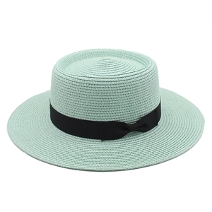 Detailed top view of mint green flat top boater hat with black ribbon and straw texture