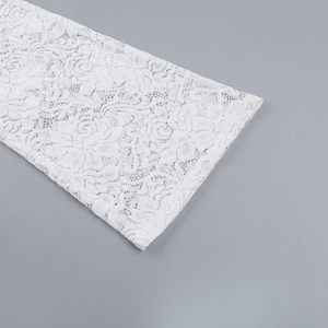 Gros plan sur un tissu en dentelle blanche avec broderie florale de roses sur la manche