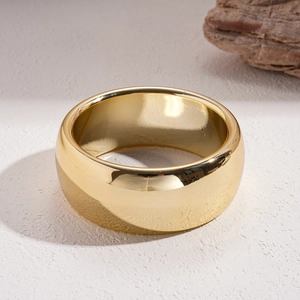Detailed view of wide minimalist gold bangle with a high-polished mirror finish surface