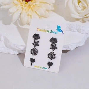 Set of four matte black stainless steel flower studs on white display card
