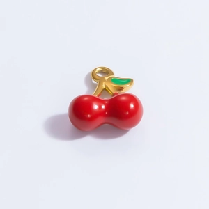 Detail of red cherry pendant with golden stem and green leaves for DIY jewelry making