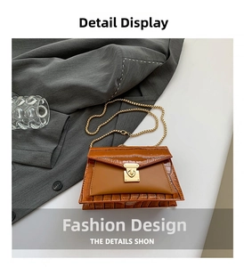 Macro detail of brown crocodile textured bag with gold metal chain and turn-lock